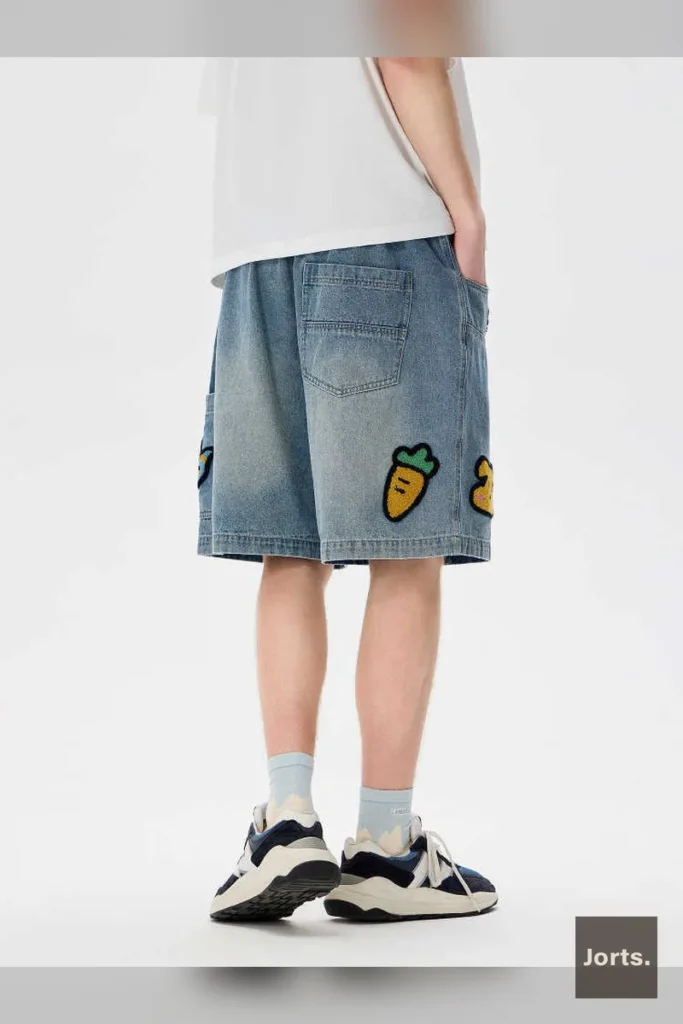 Close-up of unique appliqué embroidery on men's workwear denim shorts, showcasing vintage-inspired craftsmanship.