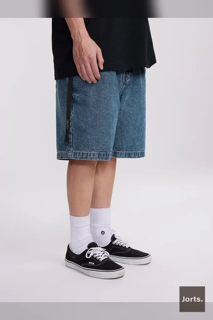 Side profile of men's dark blue denim shorts, showcasing the fifth-length cut and mid-waist design