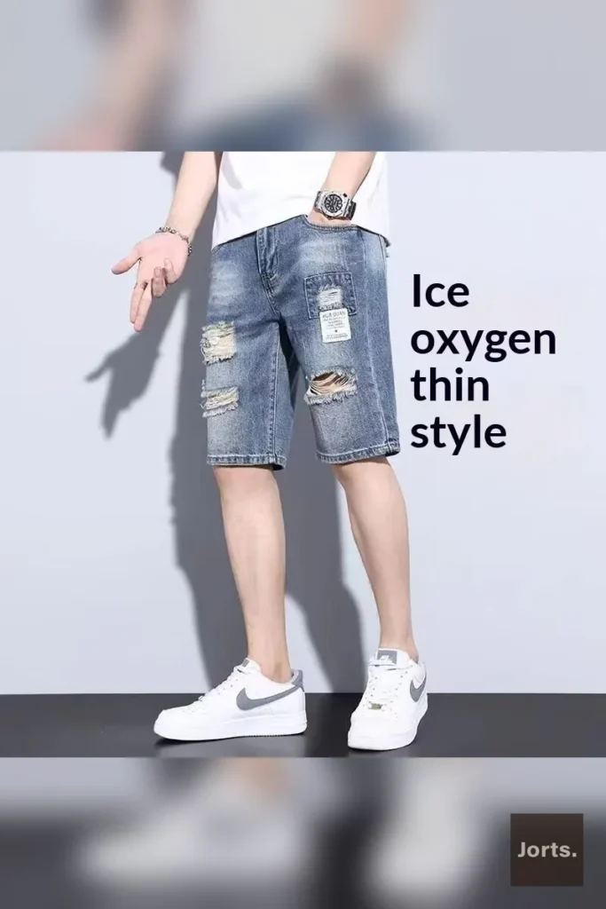 Close-up of the mid-waist and zipper fly on men's ripped light blue jorts.