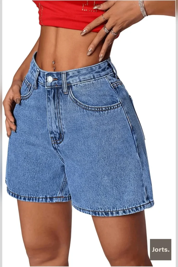 Texture shot of the denim cotton fabric of the blue straight-leg jorts, showing slight stretch.